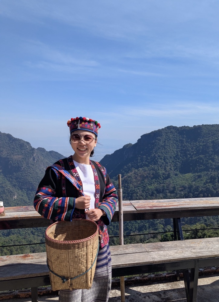 Yi Li in traditional dress in a mountain landscape